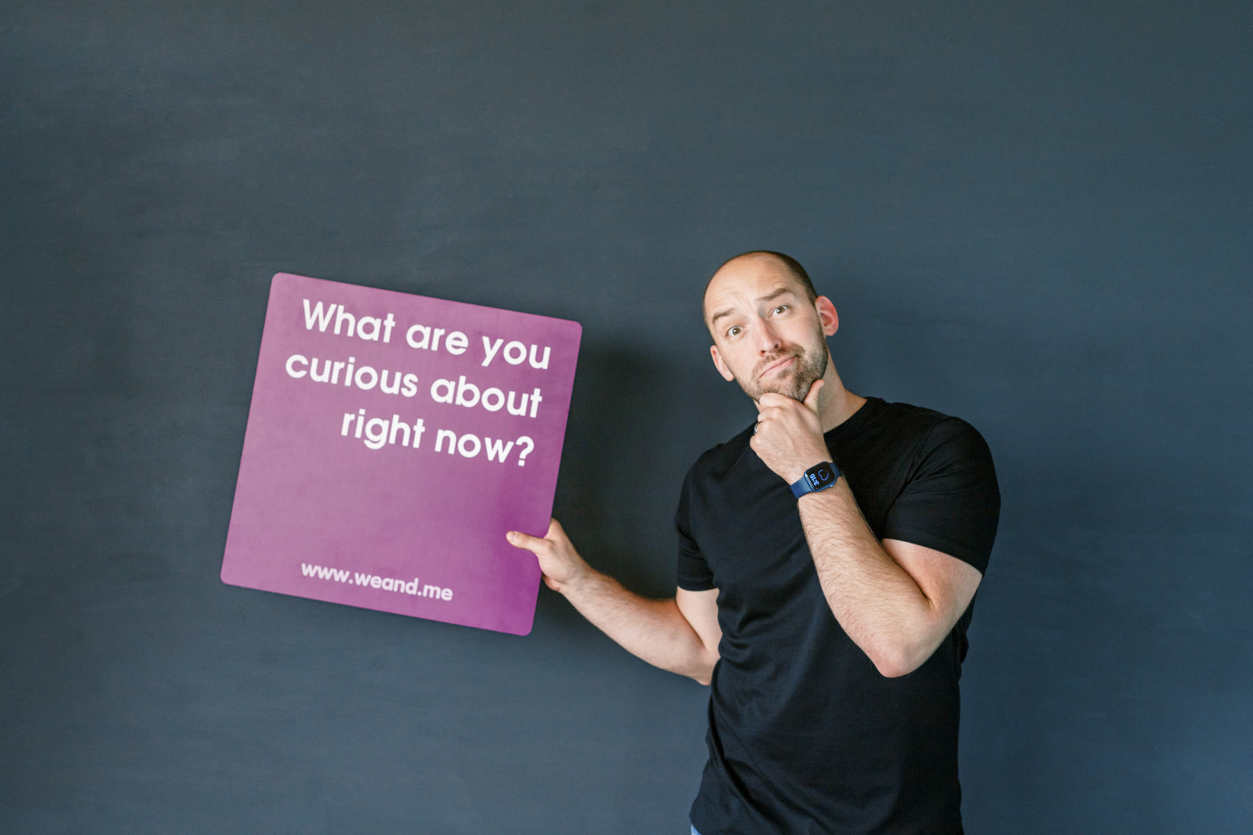 Chad Littlefield holding a card that asks 'What are you curious about right now?'